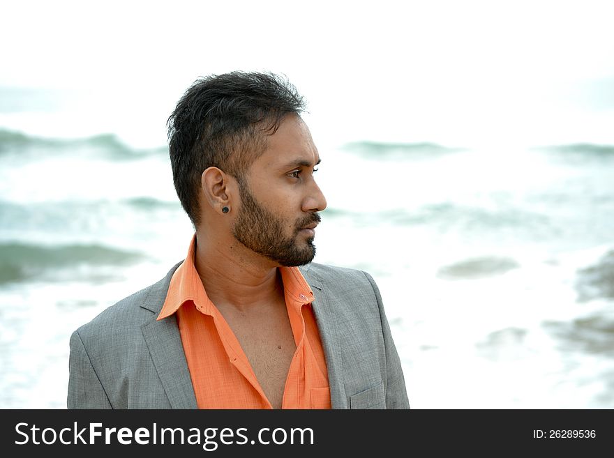 Asian indian man standing in front of beach. Asian indian man standing in front of beach
