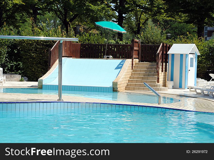 Limpid swimming pool and a waterslide without people