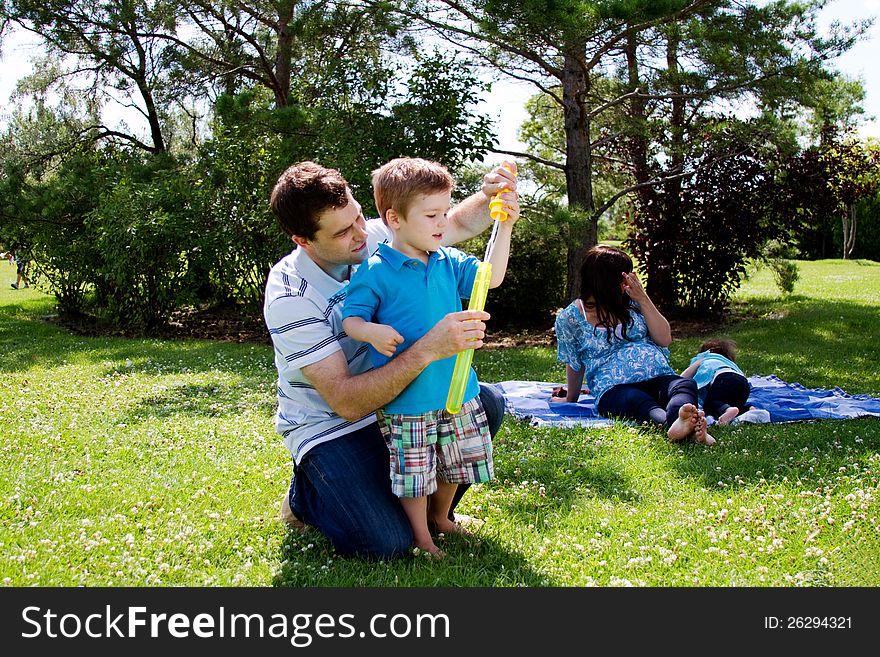 Father helping child blow bubbles