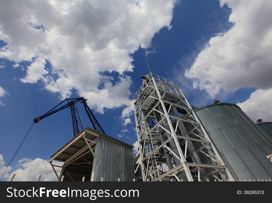 Silos port against the background of dramatic sky with clouds.