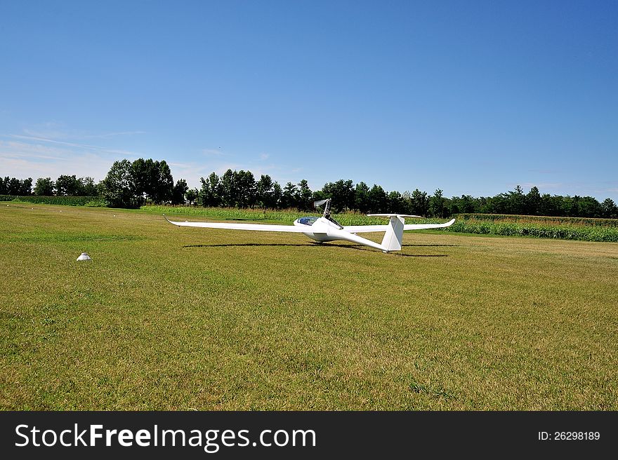 Glider or motor glider takes off from white grass runway to fly. Glider or motor glider takes off from white grass runway to fly