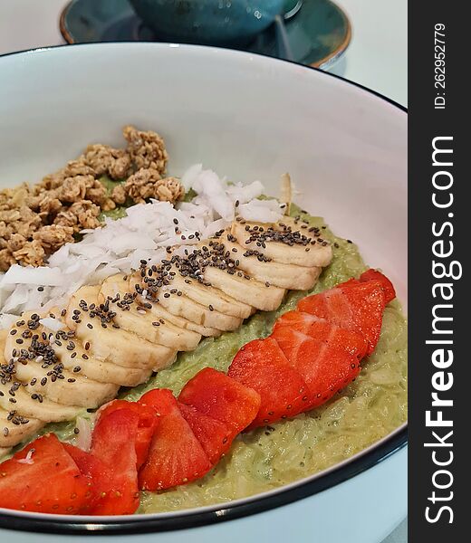 Bright Green Porridge With Pieces Of Fruit: Strawberry And Banana