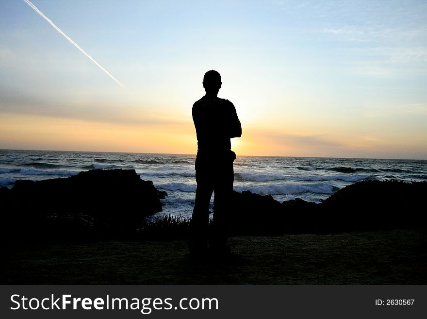 Man watching the sun set over the Pacific Ocean. Man watching the sun set over the Pacific Ocean