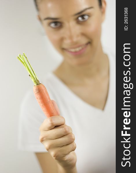 Girl holding carrot with her hand. Girl holding carrot with her hand