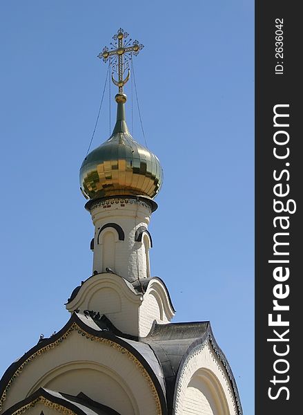 The dome of church with a gold cross is photographed on a background of the sky