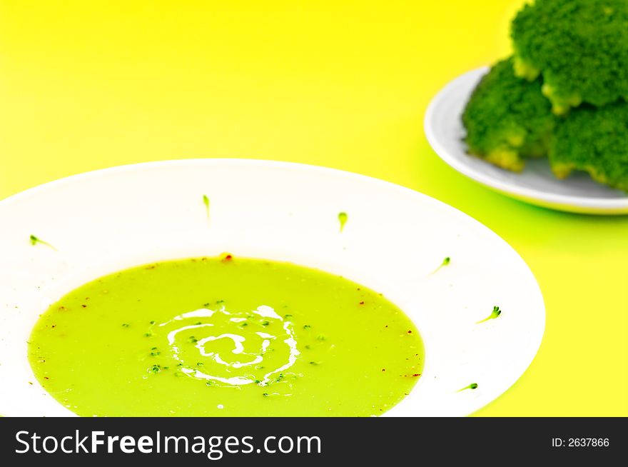 Fresh broccoli soup over a yellow background