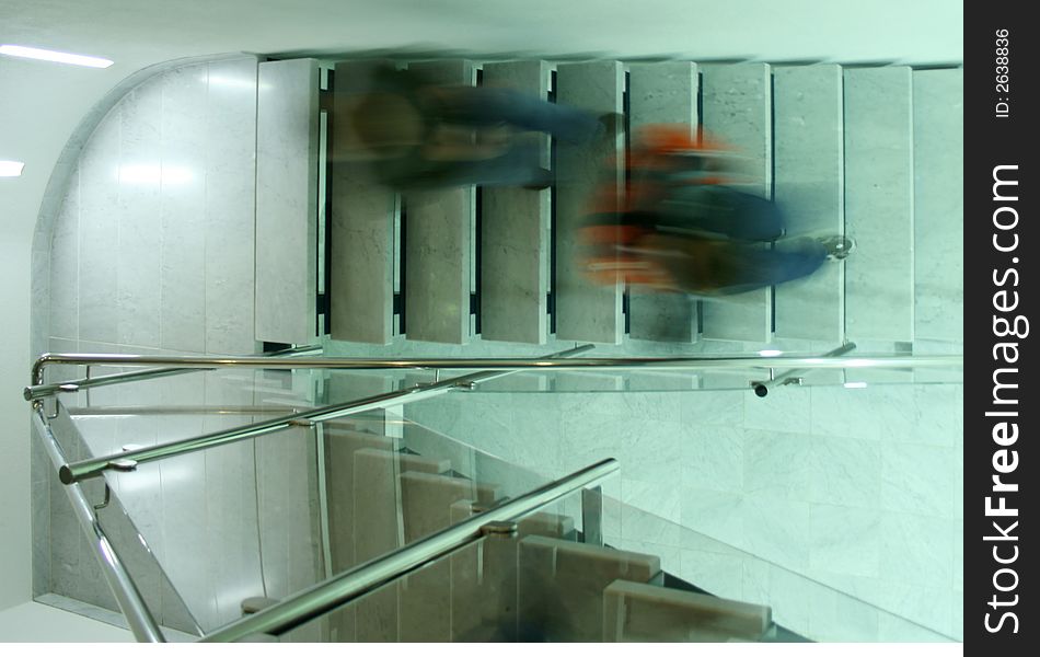 Persons in a staircase walking downstairs