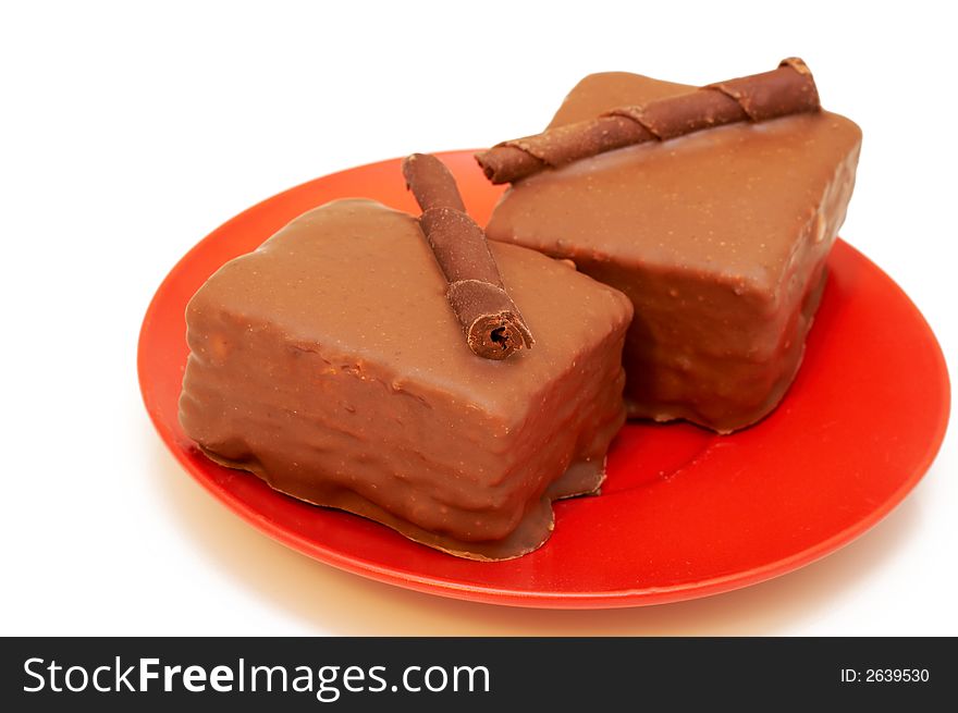 Two chocolate mini cakes on red plate, shot on white background