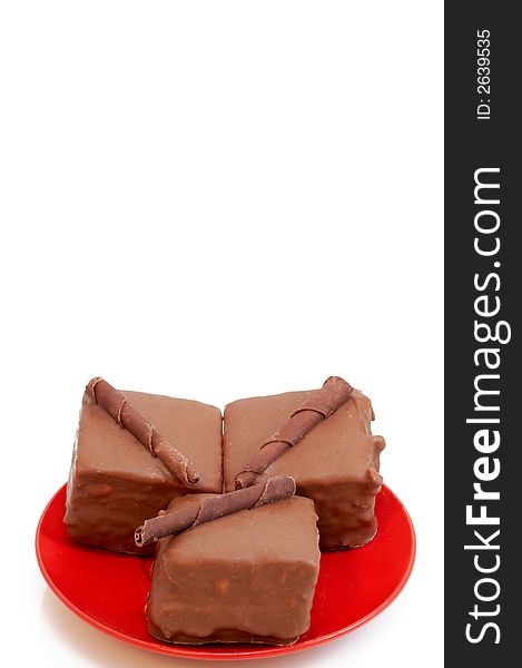 Two chocolate mini cakes on red plate, shot on white background. Two chocolate mini cakes on red plate, shot on white background