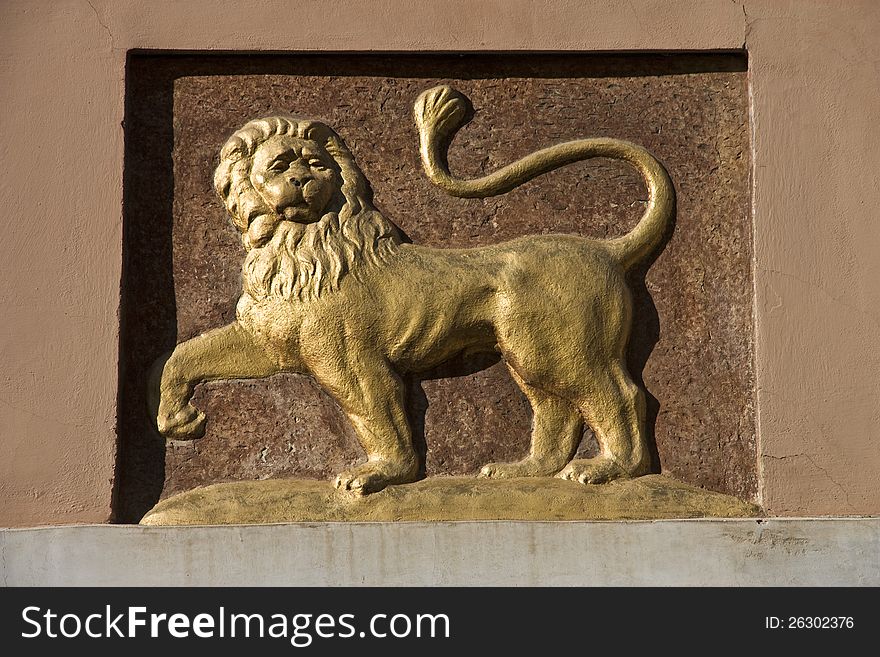 Detail yellow lion carved on the wall of the house. Detail yellow lion carved on the wall of the house