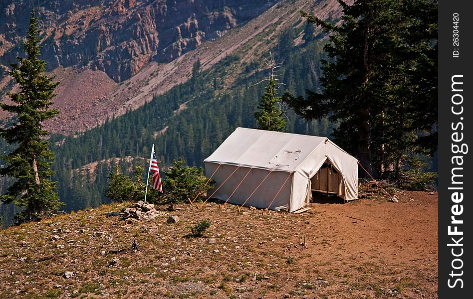 Camp with American flag on a cliff in the mountains. Camp with American flag on a cliff in the mountains