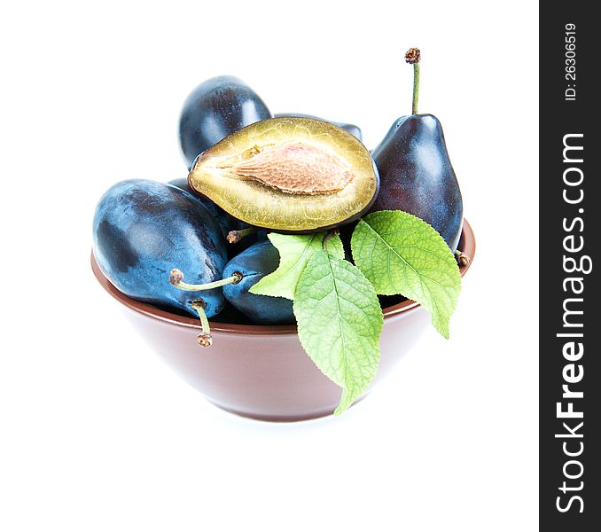 Bowl full of plums   on a white background