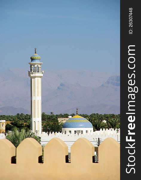 Omani landscape, mountains, mosque and palm trees.
