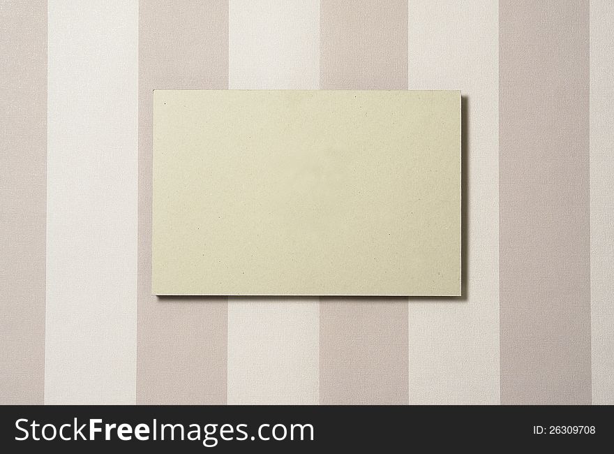 Cardboard rectangle on striped wallpaper, with shadow. Cardboard can easily be replaced in PS by any other image. Cardboard rectangle on striped wallpaper, with shadow. Cardboard can easily be replaced in PS by any other image.