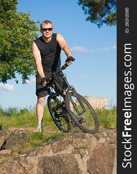 Young man on a mountain bike takes a break while mountain biking
