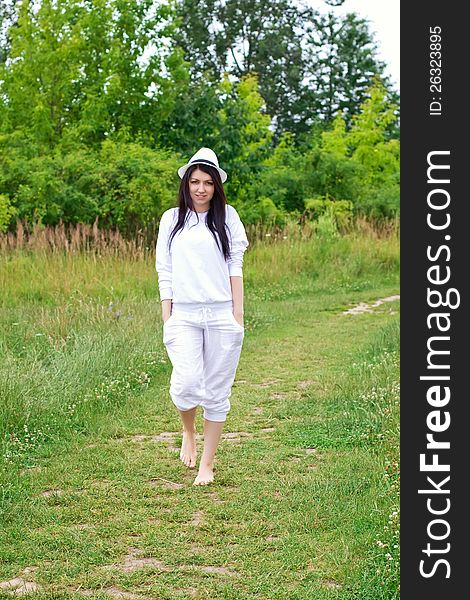 Young woman in white clothing walking outdoors. Young woman in white clothing walking outdoors
