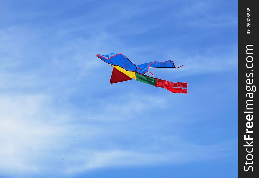 Colorful kite flying high in the blue summer sky. Colorful kite flying high in the blue summer sky