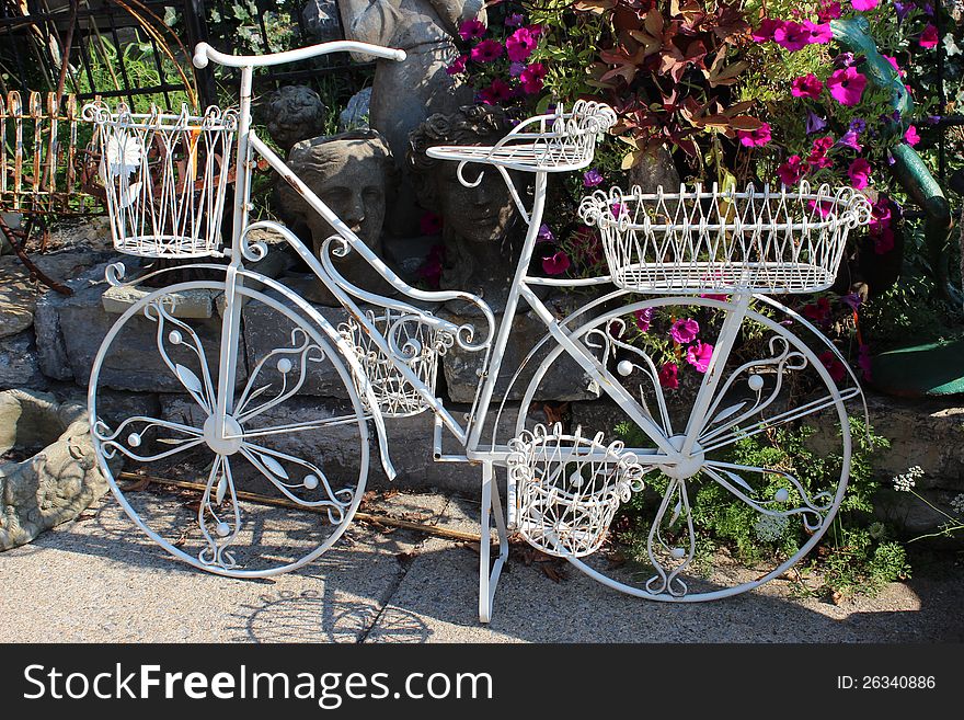 Pretty white metal bike with several wire baskets that can be used to display flowers or other items during the four seasons of the year. Pretty white metal bike with several wire baskets that can be used to display flowers or other items during the four seasons of the year.