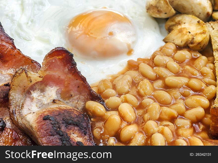 Typical Full English breakfast. Egg, Bacon, beans, mushroom and bacon. Typical Full English breakfast. Egg, Bacon, beans, mushroom and bacon.