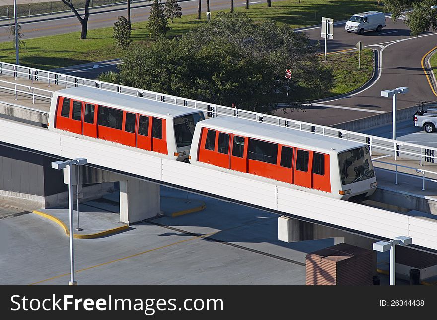 Red monorail train at an airport