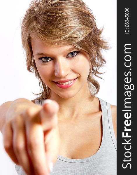 Studio portrait of a beautiful blonde girl pointing to the camera