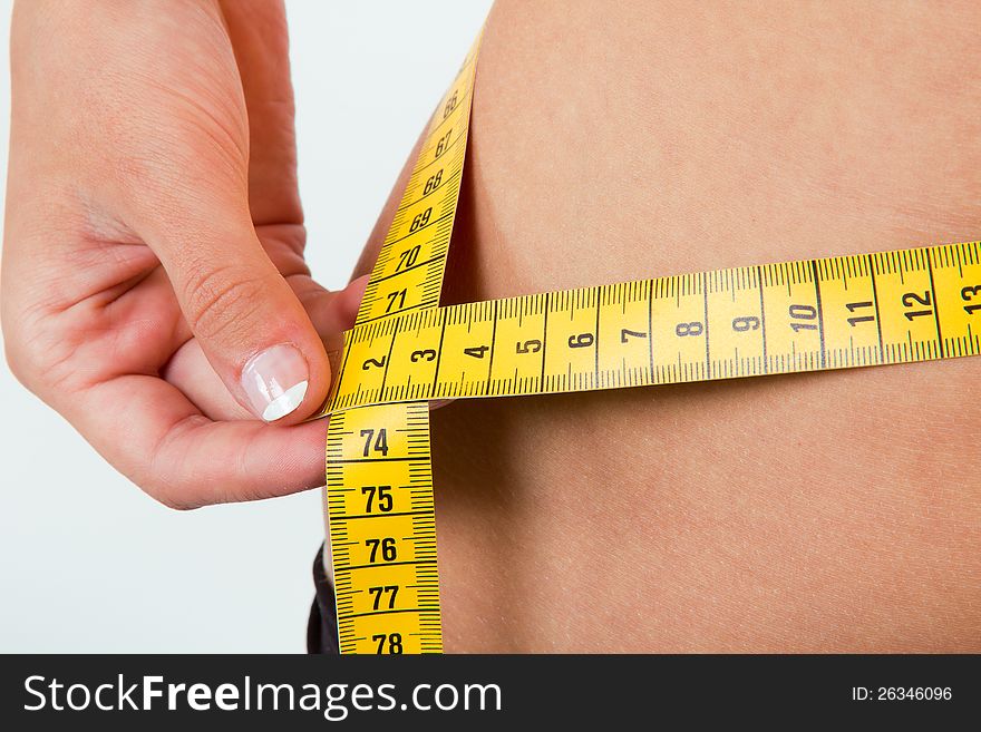 Slimming woman body in panties with measure on white background