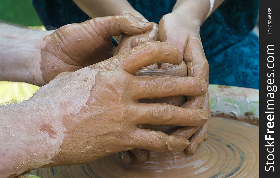 Hands of a potter, creating an earthen jar on the circle