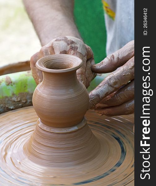 Hands of a potter, creating an earthen jar on the circle