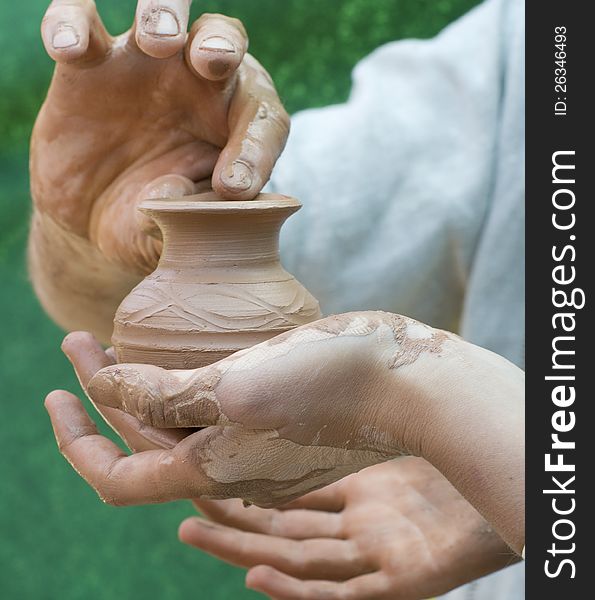 Close-up of hand holding pottery an jar. Close-up of hand holding pottery an jar