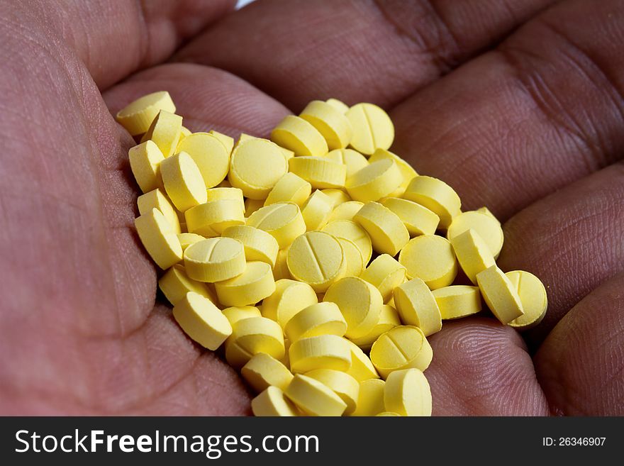 Yellow pill  in hand