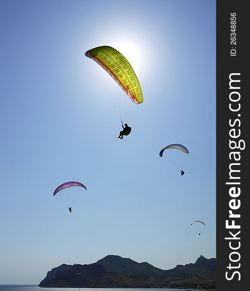 Few paragliders in the blue sky above the sea. Few paragliders in the blue sky above the sea