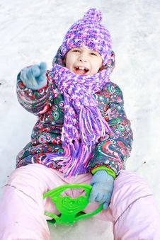 Girl Rolls Down Hill In Winter Park Stock Image