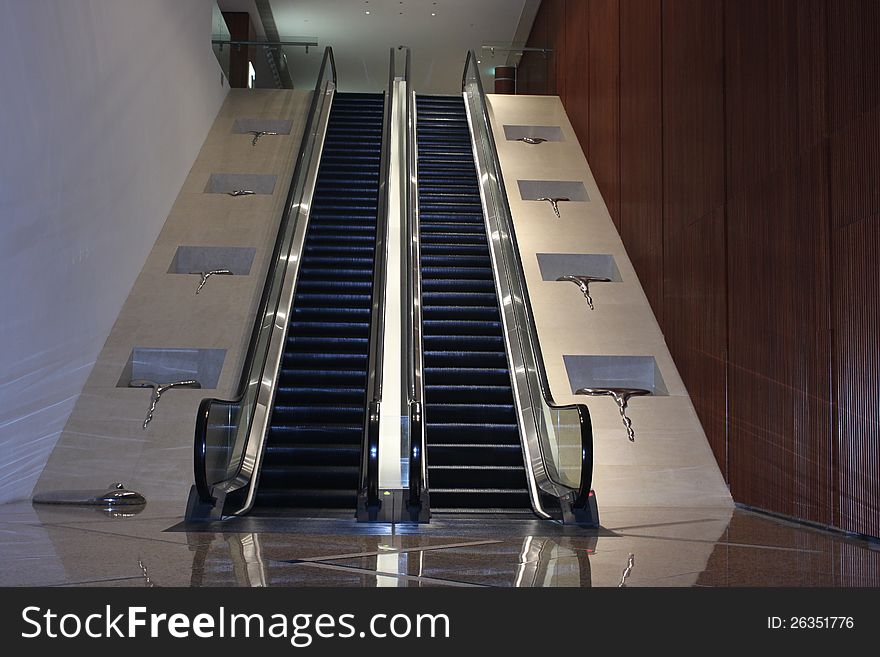 A escalator in a office building with art work in both side. A escalator in a office building with art work in both side.