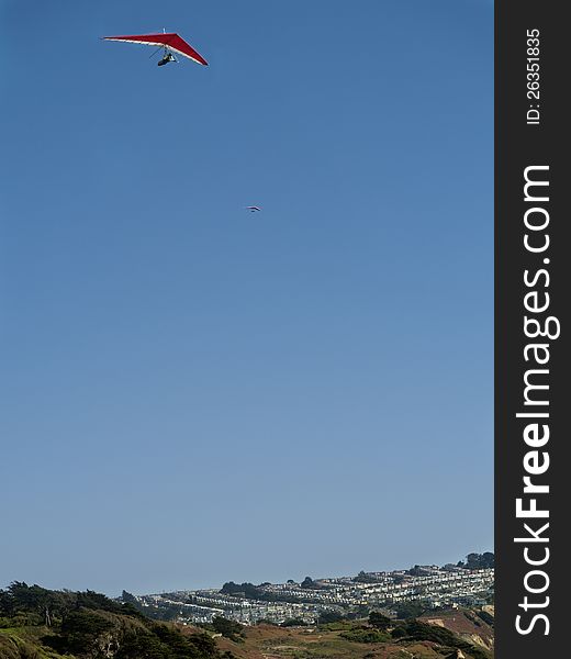 Red and white hang glider high up in the sky. Gorgeous weather and good thermal winds. Red and white hang glider high up in the sky. Gorgeous weather and good thermal winds