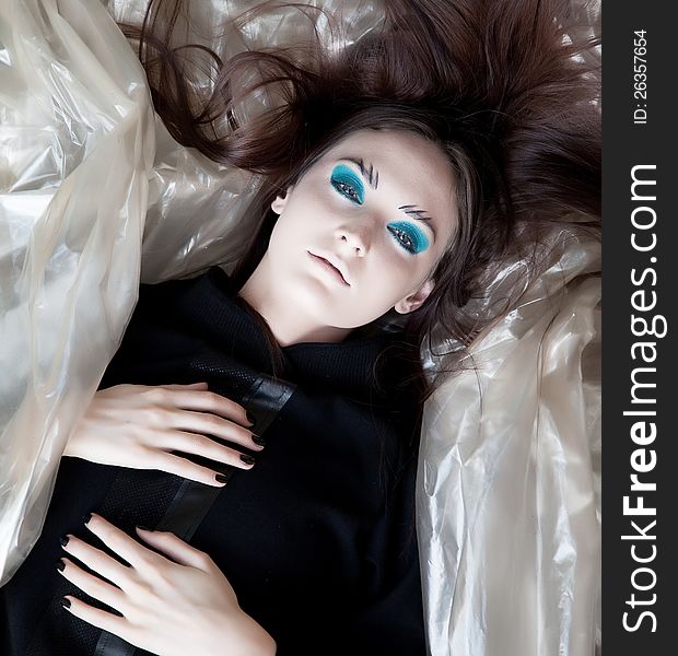 Beauty bright woman lying on a pieces of fashion fabrics. Beauty bright woman lying on a pieces of fashion fabrics