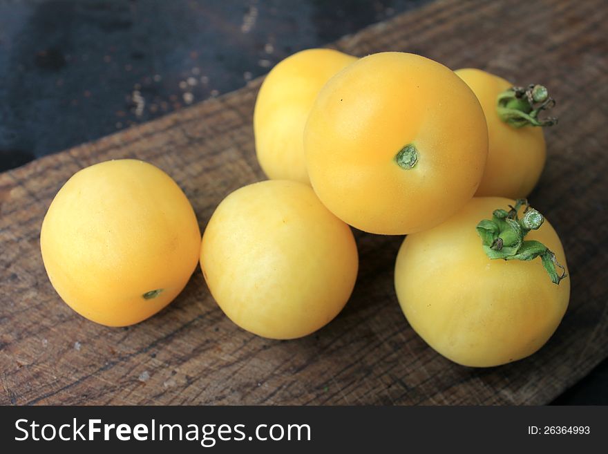 Beautiful yellow tomatoes on a wooden background close-up