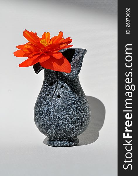 Dark vase with orange flower. Dark vase with orange flower