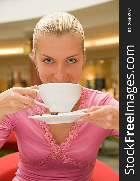 Attractive blond girl drinking coffee in a restaurant
