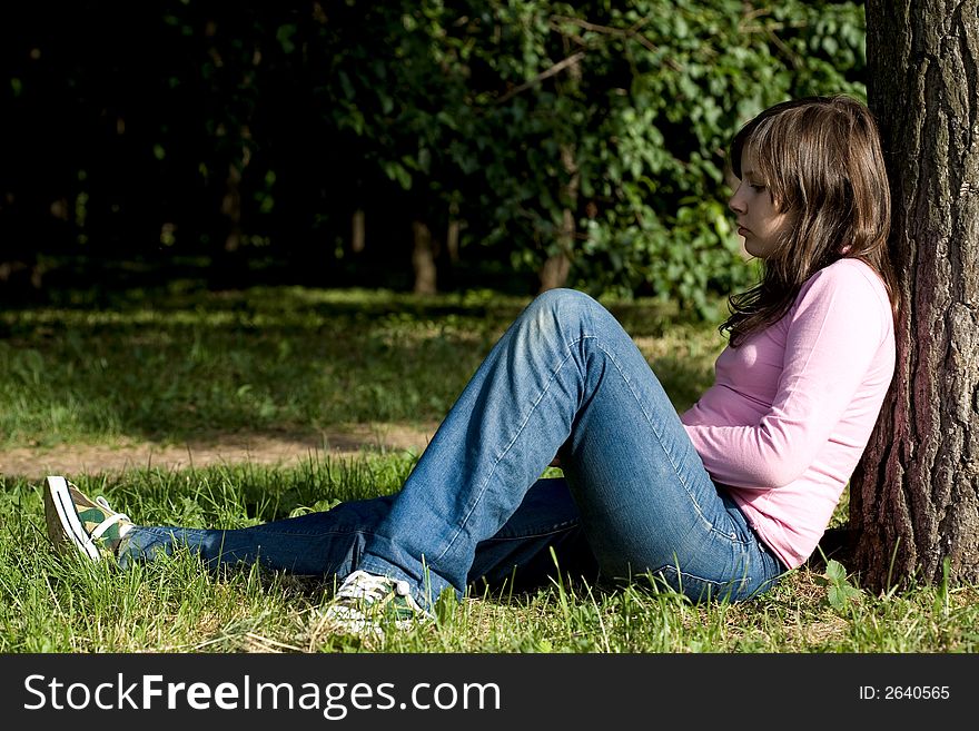 Little girl sitting under the tree. Little girl sitting under the tree