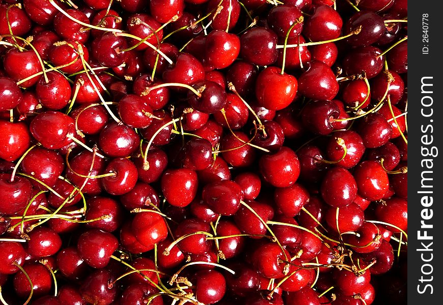 Red sweet cherries in bright sunshine, background. Red sweet cherries in bright sunshine, background