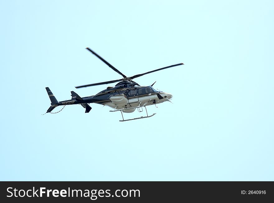A Private Heliocopter flying against a Blue Sky. A Private Heliocopter flying against a Blue Sky