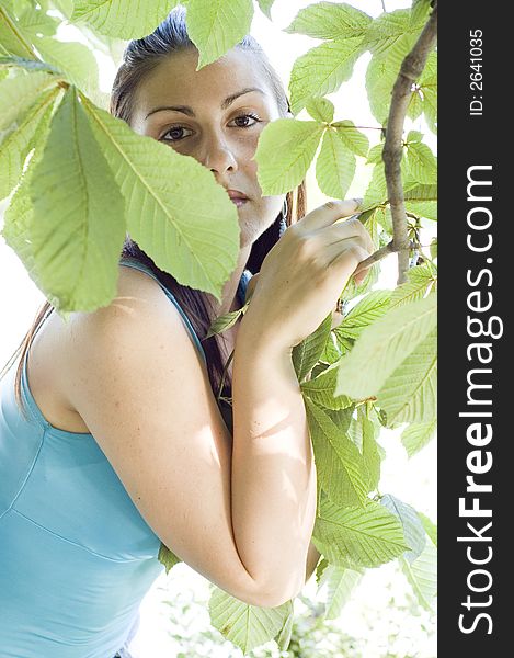 Young woman relaxing in the cascade, backlit, visible lens flare