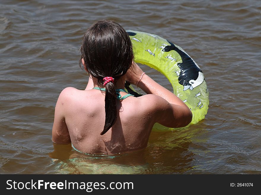 A child blows buoy in water. A child blows buoy in water