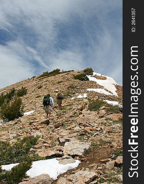 Two hikers go for the top of the mountain. Two hikers go for the top of the mountain