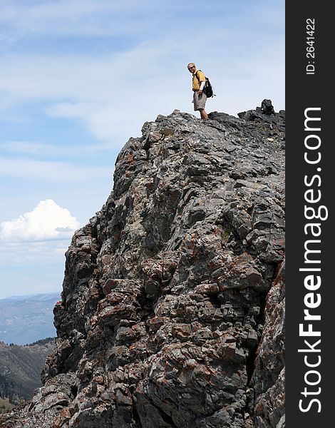 Hiker nears the top of a rocky ridge. Hiker nears the top of a rocky ridge