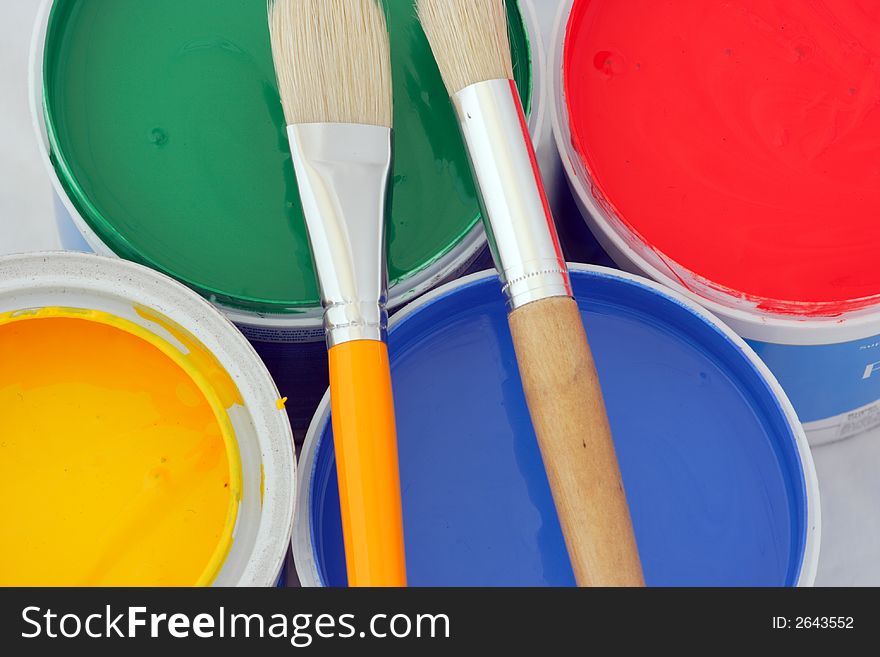 Vertical picture of paints in red,blue,green and yellow and brushes. Vertical picture of paints in red,blue,green and yellow and brushes