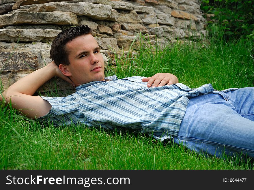 Young, relaxed man lying on the grass in the graden. Young, relaxed man lying on the grass in the graden