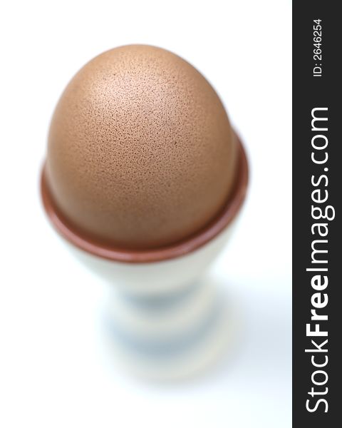 A Single boiled egg in eggcup for breakfast against white background