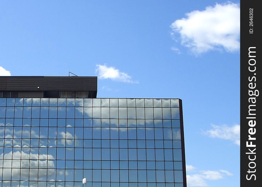 An off ice building with mirrored windows reflects the clouds. An off ice building with mirrored windows reflects the clouds.