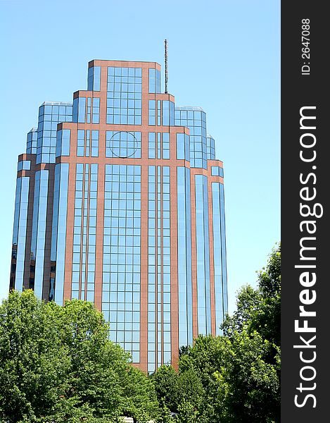 Brick and glass building rising from the trees